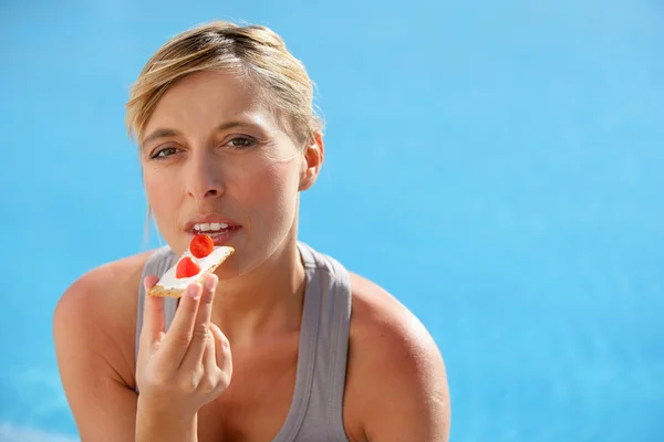 Žena jíst topinky s plátky jahoda — Stock fotografie