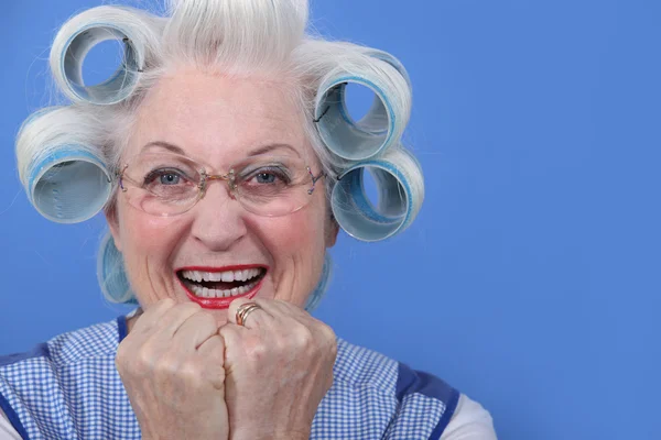 Senior woman with curlers in her hair laughing Royalty Free Stock Photos