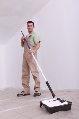 Handyman painting with a longhandled cylinder clipart