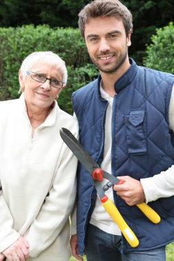 Young man and older woman in garden clipart