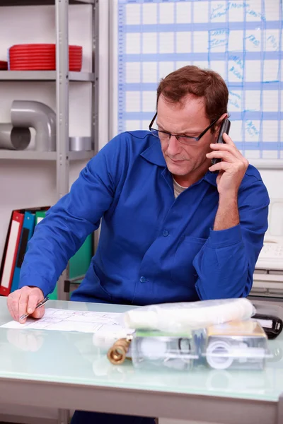 Plumber on the phone in office — Stock Photo, Image