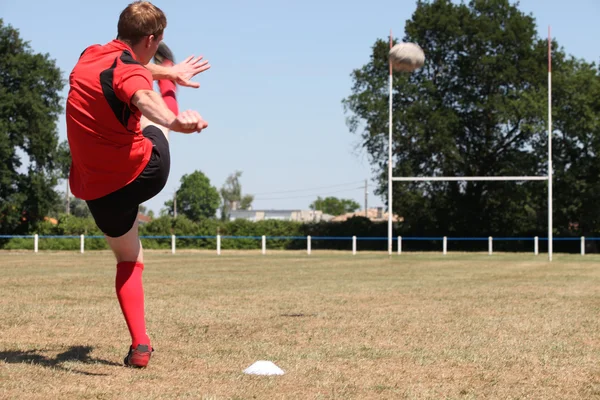 A rugby player kicking a ball — Zdjęcie stockowe
