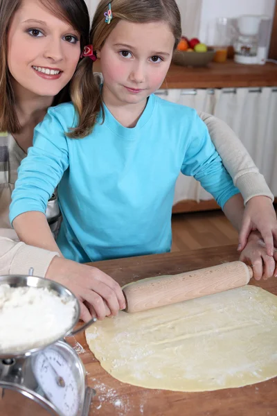 Mãe e filha rolando pastelaria — Fotografia de Stock