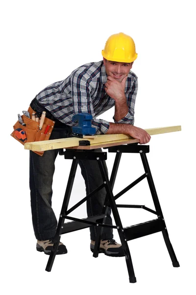 Carpinteiro inclinado no banco de trabalho — Fotografia de Stock