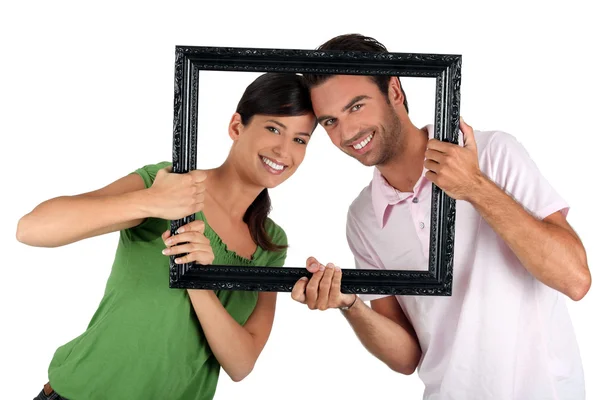 Couple holding empty art frame — Stockfoto