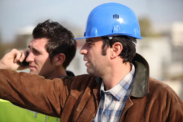 Construction supervisor and assistant observing — Stock Photo, Image