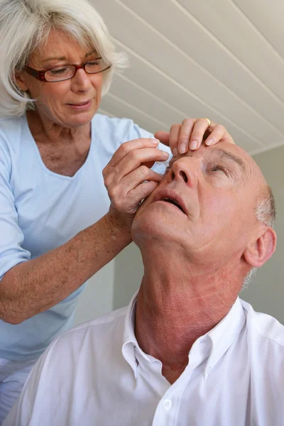 Γυναίκα που βοηθούν το σύζυγό της με φακούς επαφής — Φωτογραφία Αρχείου