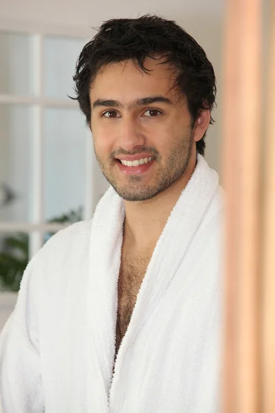 Lachende jonge man in een badjas — Stockfoto