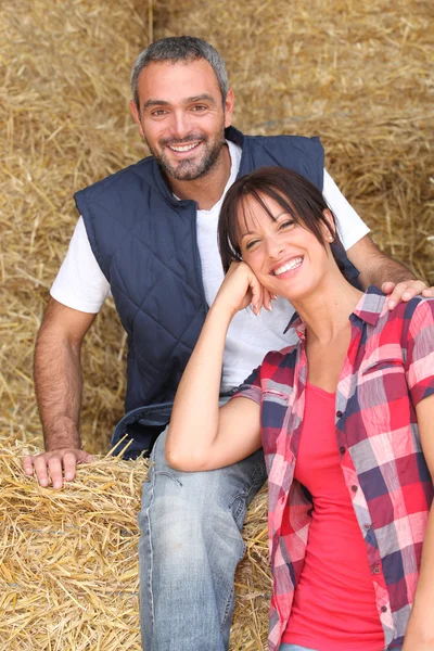 Agricultor e esposa sentados no feno — Fotografia de Stock