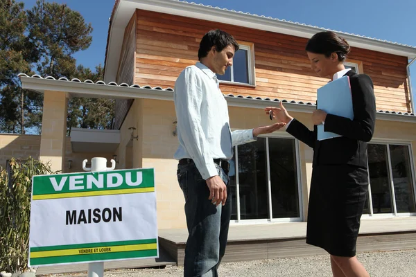 Agente inmobiliario entregando las llaves de un nuevo hogar — Foto de Stock