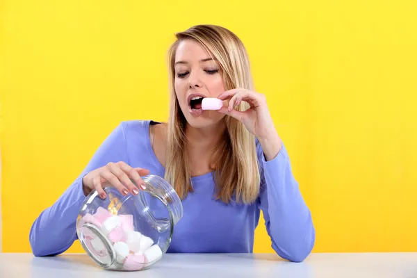 Donna che mangia marshmallow dal barattolo — Foto Stock