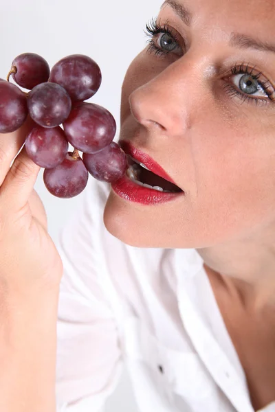 Junge Frau isst Weintrauben — Stockfoto