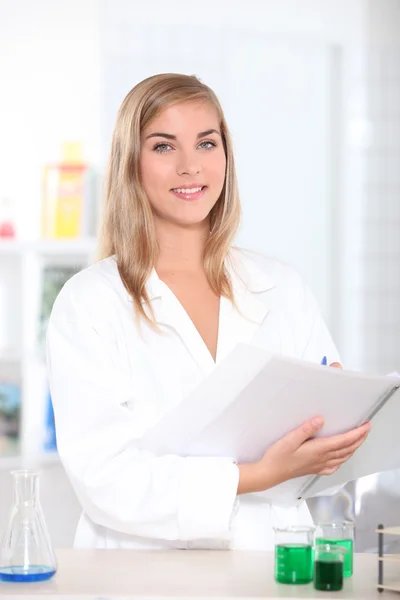 Science student noting results of her experiment — Stock Photo, Image