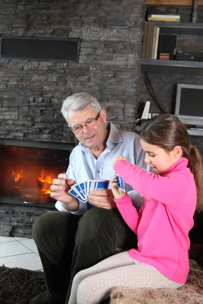 Klein meisje playing kaartspel met opa — Stockfoto