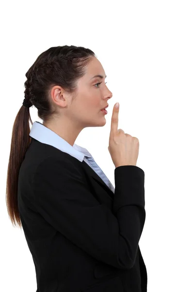 Woman holding her index finger to her lips — Stock Photo, Image