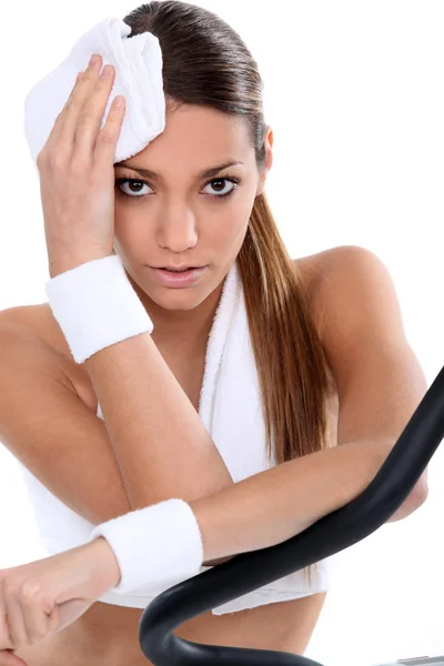 Femme dans la salle de gym en utilisant la machine à cycle — Photo