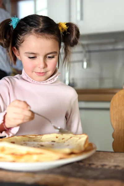 Little girl eating pancakes in kitchen — Stock Photo, Image