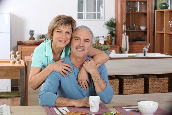 Пара средних лет завтракает вместе на кухне — стоковое фото