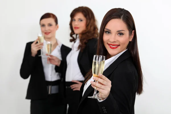 Young women in smart suit with glasses of champagne Stock Picture