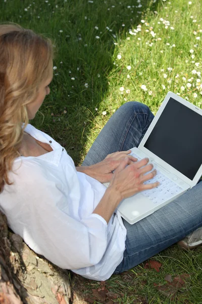 Frau benutzt Laptop im Park — Stockfoto