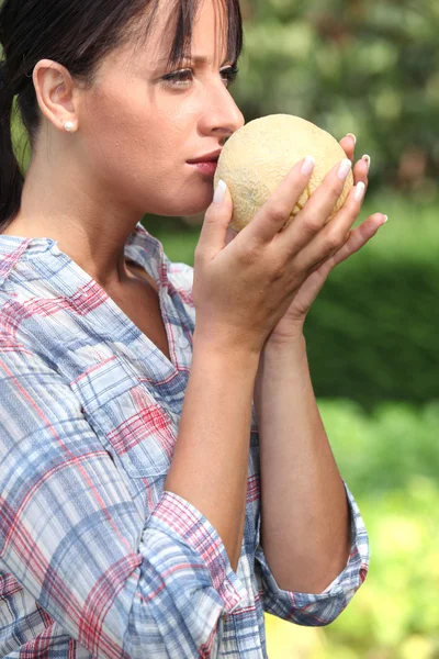 Girl smelling melon — Stock Photo, Image