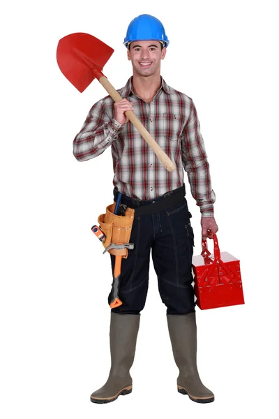 Workman holding shovel and toolbox — Stock Photo, Image