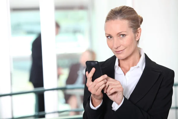 Mulher de negócios loira enviando mensagem de texto — Fotografia de Stock