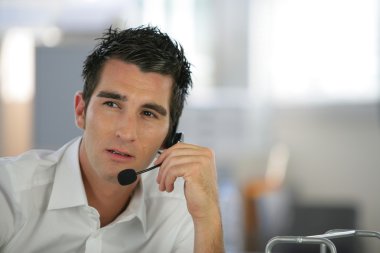 Young man using a telephone headset clipart