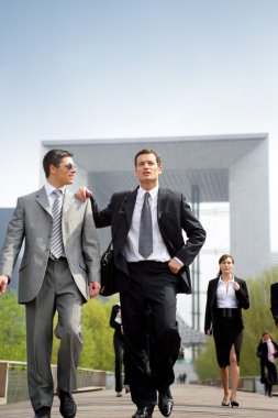 Businesspeople walking outdoors clipart