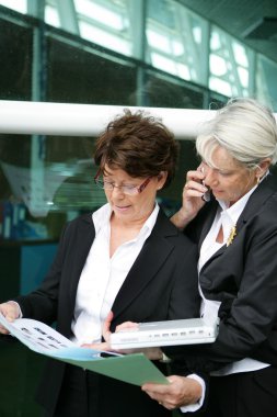 Two senior sales women on the way to a meeting clipart