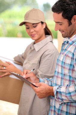 Man signing for the delivery of a parcel clipart