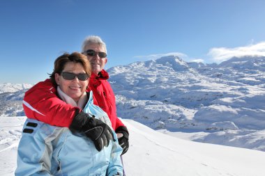 Middle-aged couple on skiing holiday clipart