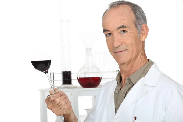 Um cientista segurando um copo de vinho em seu laboratório — Fotografia de Stock