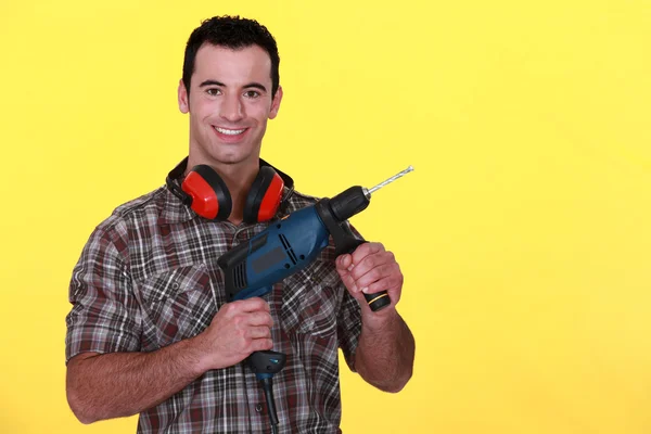 Man with power drill and earmuffs — Stock Photo, Image