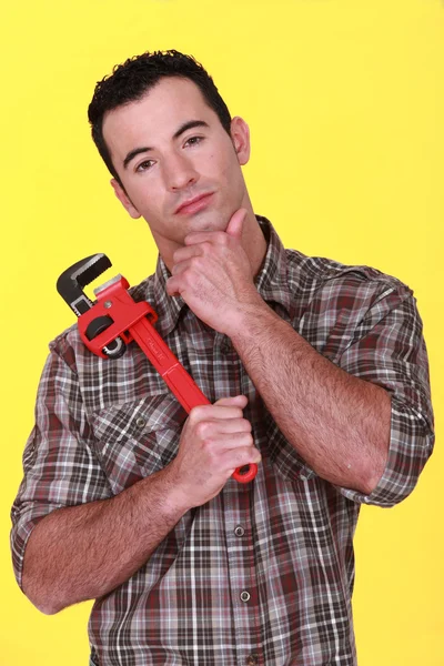 Obrero sosteniendo una llave de tubo — Foto de Stock