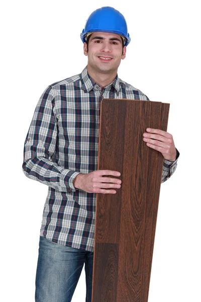 A male carpenter holding a couple of planks. — Stock Photo, Image