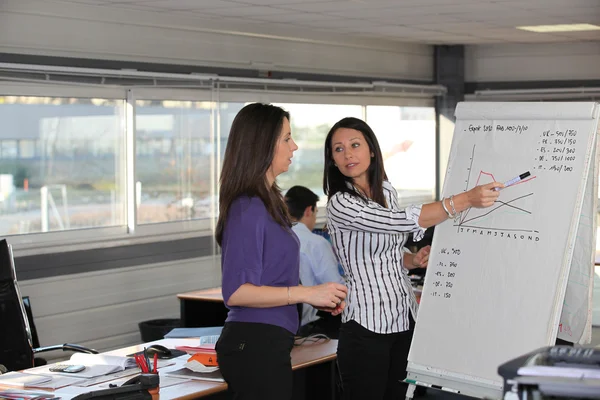 Mulheres discutindo um gráfico de crescimento em um escritório — Fotografia de Stock