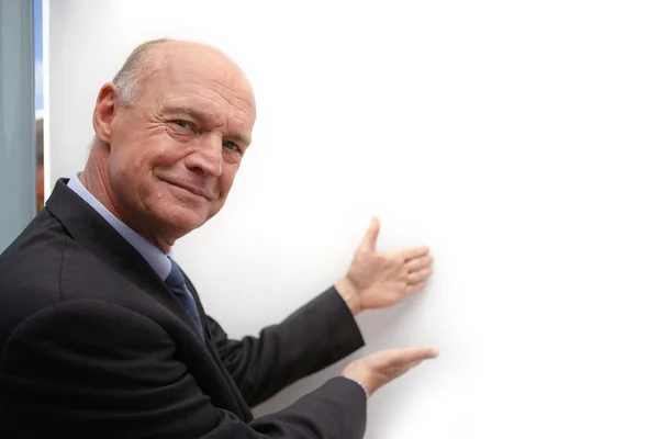 Bald businessman drawing attention to white-board — Stock Photo, Image