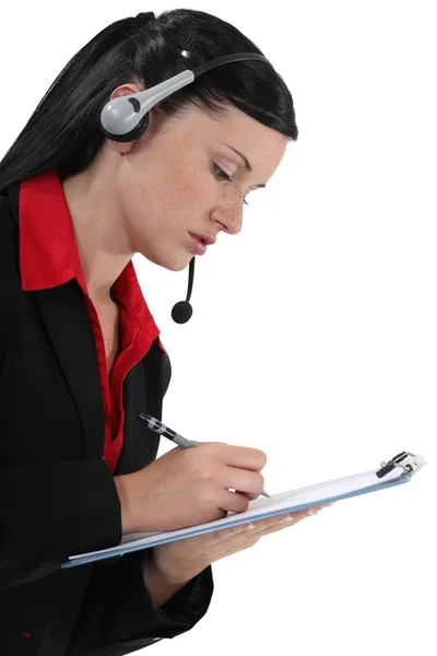 Mujer joven con auriculares y bloc de notas — Foto de Stock