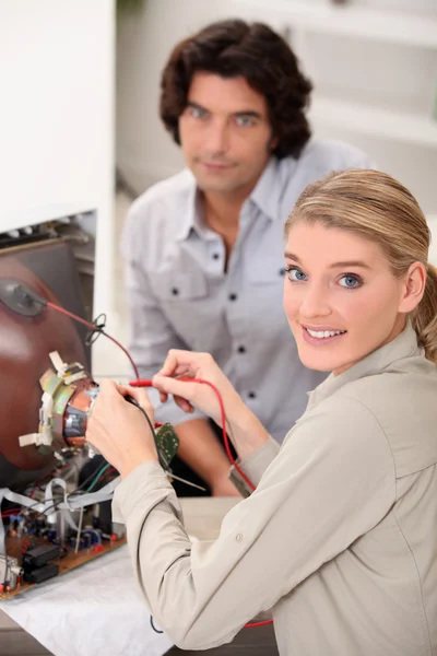 Female technician repairing television — Stock Photo, Image
