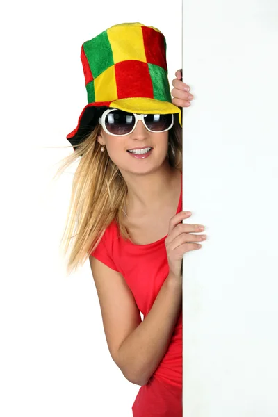 Junge Frau mit verrücktem Hut und einem Brett, das für Ihre Nachricht leer gelassen wurde — Stockfoto