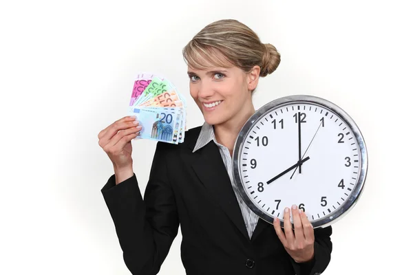 Mulher segurando relógio e notas bancárias — Fotografia de Stock