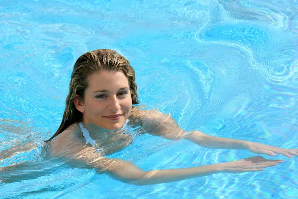 Mujer joven nadando en una piscina — Foto de Stock