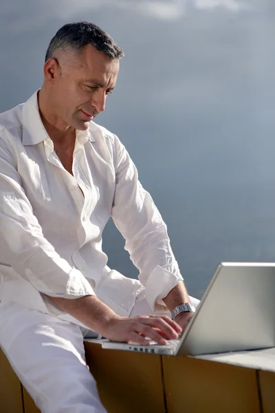 Man met laptop op een terras — Stockfoto