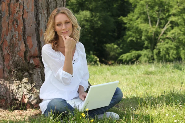 Kobieta korzysta z laptopa w parku — Zdjęcie stockowe