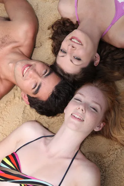 Teenagers lying on the sand — Stock Photo, Image