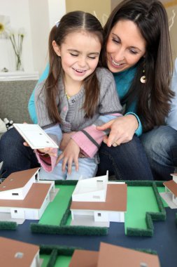 Female architect at home with young daughter clipart