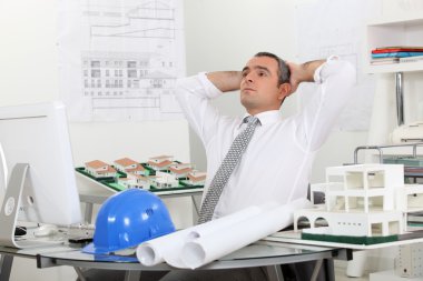 Architect relaxing in his office clipart