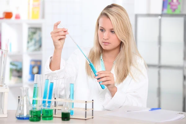Dziewczyna w laboratorium przy użyciu probówek — Zdjęcie stockowe