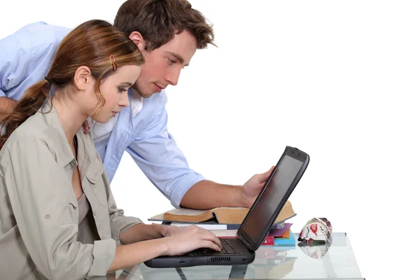 Um casal de estudantes sobre seu laptop . — Fotografia de Stock